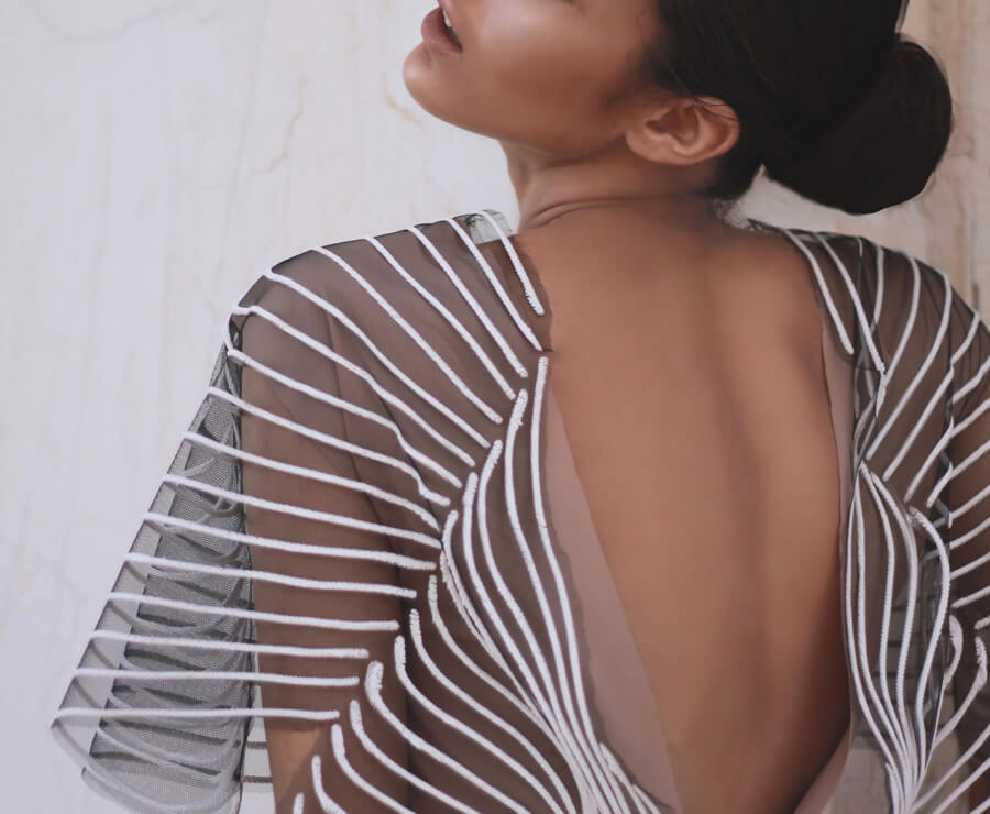 Model wearing a sheer backless dress